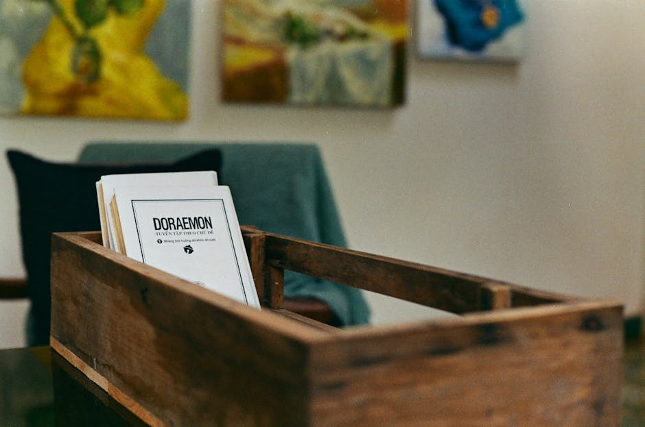 Cozy interior scene with books in a wooden box and abstract art on walls.